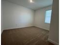 Simple bedroom with neutral carpet and a single window allowing natural light at 1849 Sunshine Peak Dr, Minneola, FL 34715