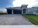 Charming single-story home featuring a three-car garage and a beautifully paved driveway at 1849 Sunshine Peak Dr, Minneola, FL 34715