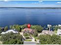 This aerial view showcases the home's waterfront lot and lake views at 1956 Brantley Cir, Clermont, FL 34711