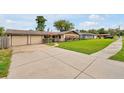 Inviting ranch-style home with a two-car garage, American flag, and a well-maintained lawn at 2007 Mosher Dr, Orlando, FL 32810