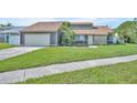 Charming single-Gathering home featuring a two-car garage, well-maintained lawn and beautiful landscaping at 2104 Winding Ridge S Ave, Kissimmee, FL 34741