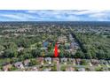 Property aerial view showcasing the home's location near a pond and surrounded by lush greenery in a residential community at 2766 Privada Dr, The Villages, FL 32162