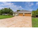 Spacious three-car garage with an expansive stamped concrete driveway and well-manicured lawn at 2904 Avalos Dr, The Villages, FL 32162