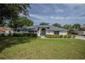 Charming single-story home with lush front yard and mature trees offering curb appeal at 33913 Sabal Way, Leesburg, FL 34748