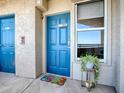 Condo entrance with a blue door, a window, and a decorative plant at 3425 S Atlantic Ave # 1101, Daytona Beach, FL 32118
