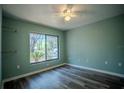 Bright bedroom features wood floors, a ceiling fan, and a large window with scenic views at 3930 Griffin Ave, Lady Lake, FL 32159