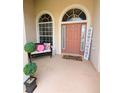 Inviting front porch with stylish decor and potted greenery at 3969 Derby Glen Dr, Clermont, FL 34711
