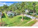 Landscaped front yard featuring a lush lawn and mature trees leads to this single-story home at 410 E Gulley Ave, Oakland, FL 34760