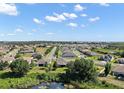Scenic aerial view showcasing a peaceful neighborhood, mature trees, and a tranquil pond with a natural habitat at 440 Bellissimo Pl, Howey In The Hills, FL 34737