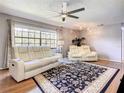 Cozy living room with modern furniture, a ceiling fan, and a large window for natural light at 500 Newell Hill Rd # 113D, Leesburg, FL 34748