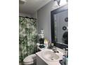 A compact bathroom features a white vanity, patterned shower curtain, and decorative accents at 508 Villa Del Sol Cir # 105, Orlando, FL 32824