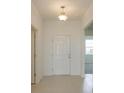 Bright foyer features neutral tile flooring and a classic pendant light fixture at 520 Silver Palm Dr, Haines City, FL 33844