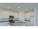 Modern kitchen with white cabinets, granite countertops, and stainless steel appliances at 520 Silver Palm Dr, Haines City, FL 33844