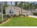Charming single-story home with a well-manicured lawn and lush landscaping with palm trees at 541 Cokesbury Dr, The Villages, FL 32162