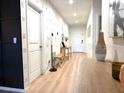 Inviting hallway with wood-look floors, stylish wall decor, and ample natural light, leading to the home's interior at 591 Black Eagle Dr, Groveland, FL 34736