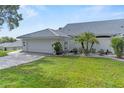 A lovely home featuring a pristine two-car garage, a brick driveway, and well-manicured landscaping at 6048 Topsail Rd, Lady Lake, FL 32159