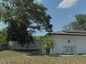 This home boasts a well-manicured lawn complemented by mature trees and a sturdy white fence at 6221 Ambassador Dr, Orlando, FL 32808