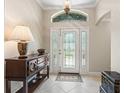 Bright foyer featuring tile floors, a decorative glass front door, and stylish furniture at 654 Poinsett Ct, The Villages, FL 32162