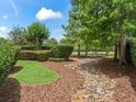Mature trees and decorative rock features line the manicured lawns of this home at 654 Poinsett Ct, The Villages, FL 32162