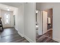 Bright entryway features elegant wood-look tile flooring, white walls, and a view of a bedroom and bathroom at 686 Black Eagle Dr, Groveland, FL 34736