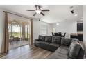 Bright living room boasts a large sliding glass door, ceiling fan, and an open layout to the dining and kitchen areas at 686 Black Eagle Dr, Groveland, FL 34736