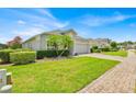 Well-maintained single-story home with green lawn, mature landscaping and a brick-paved driveway at 802 Balmoral Dr, Davenport, FL 33896