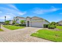 Beautiful single-story home featuring a brick-paved driveway and lush green landscaping at 802 Balmoral Dr, Davenport, FL 33896