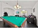 Spacious game room with a pool table, comfortable seating, and a bright chandelier at 802 Balmoral Dr, Davenport, FL 33896