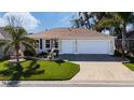 Charming single-story home featuring a manicured lawn and a spacious three-car garage at 9430 Se 176Th Saffold St, The Villages, FL 32162