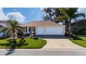 Charming single-story home featuring a manicured lawn and a spacious three-car garage at 9430 Se 176Th Saffold St, The Villages, FL 32162