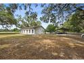 Backyard view of the home with an attached carport, fenced yard and fresh exterior paint at 9483 Cr 747, Webster, FL 33597