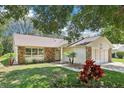 Inviting single-story home with well-manicured lawn, stone accents and a two car garage at 1011 Dundee Cir, Leesburg, FL 34788