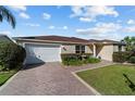 Well-maintained single-story home with a beautiful front lawn and stamped concrete driveway at 1014 Nash Loop, The Villages, FL 32162