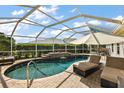 Relaxing screened-in pool area, featuring lounge chairs and a waterfall feature for resort style living at 1175 Johnston Path, The Villages, FL 32162