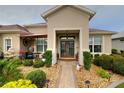 The covered front entrance has a seating area and meticulously maintained landscaping at 11868 Se 91St Cir, Summerfield, FL 34491