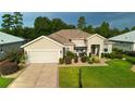 Inviting single-story home features a well-maintained lawn, beautiful landscaping and covered entrance at 11868 Se 91St Cir, Summerfield, FL 34491