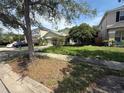 Inviting home with a two-car garage, mature tree in the front yard, and neatly manicured landscaping at 1209 Cathcart Cir, Sanford, FL 32771
