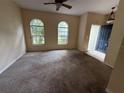 Spacious living room with carpet and natural light from arched windows in neutral tones at 1209 Cathcart Cir, Sanford, FL 32771
