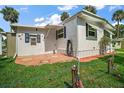 An exterior view of the home showcasing the yard with tropical plants at 124A Shady Ln, Eustis, FL 32726