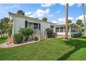 Exterior of home featuring beautiful landscaping, a small patio, and a screened in porch at 124A Shady Ln, Eustis, FL 32726