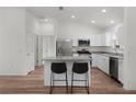 Modern kitchen with stainless steel appliances, granite countertops, white cabinetry, and island with seating at 1313 Arredondo Dr, The Villages, FL 32162