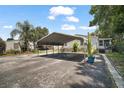 Property featuring a long driveway, carport, and tidy landscaping at 13137 Kansas Ave, Astatula, FL 34705