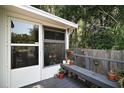 Cozy screened in porch with view of trees and a wooden bench at 13137 Kansas Ave, Astatula, FL 34705
