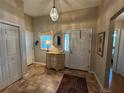 Bright and welcoming foyer with tile flooring and decorative accents on antique furniture at 1512 Nueva Pl, The Villages, FL 32159