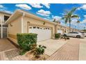 Townhome exterior with a two-car garage and lush landscaping showcasing the community's well-maintained grounds at 17406 Chateau Pine Way, Clermont, FL 34711