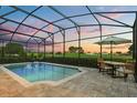 Sparkling screened-in pool area with a tranquil view, outdoor dining set, and resort-style ambiance at 17700 Sawgrass Run, Tavares, FL 32778