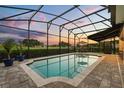 Gorgeous screened-in pool with brick pavers, offering a peaceful view and ample space for relaxation at 17700 Sawgrass Run, Tavares, FL 32778