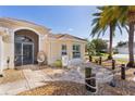 Inviting front entrance with a charming patio area and tropical landscaping at 2077 Vickers Pl, The Villages, FL 32163