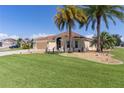 Lovely single-story home with a lush green lawn and mature palm trees at 2077 Vickers Pl, The Villages, FL 32163