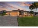 Charming single-story home with a well-manicured lawn and a beautiful, patterned driveway at 2077 Vickers Pl, The Villages, FL 32163